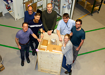 A group of people standing around a shipping crate that contains the new DA20 analyser from Scienta Omicron.  | © Scienta Omicron 